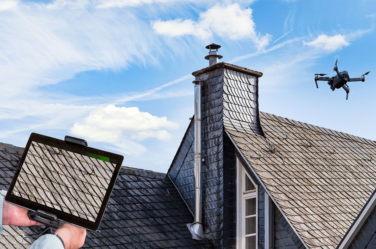 Drone in the air inspecting the roof of the house